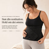 Woman wearing the black Relievoo postpartum support belt over a black vest top, holding the front support strap rvpumpen rvhasar