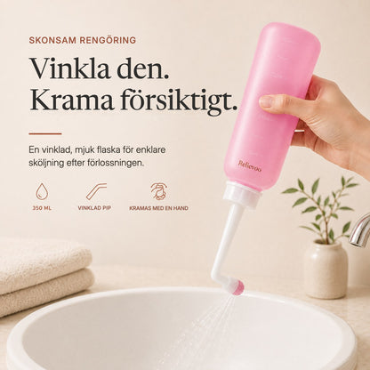 Hand squeezing the pink 350 ml Relievoo peri bottle with its angled nozzle over a basin rvpumpen rvhasar